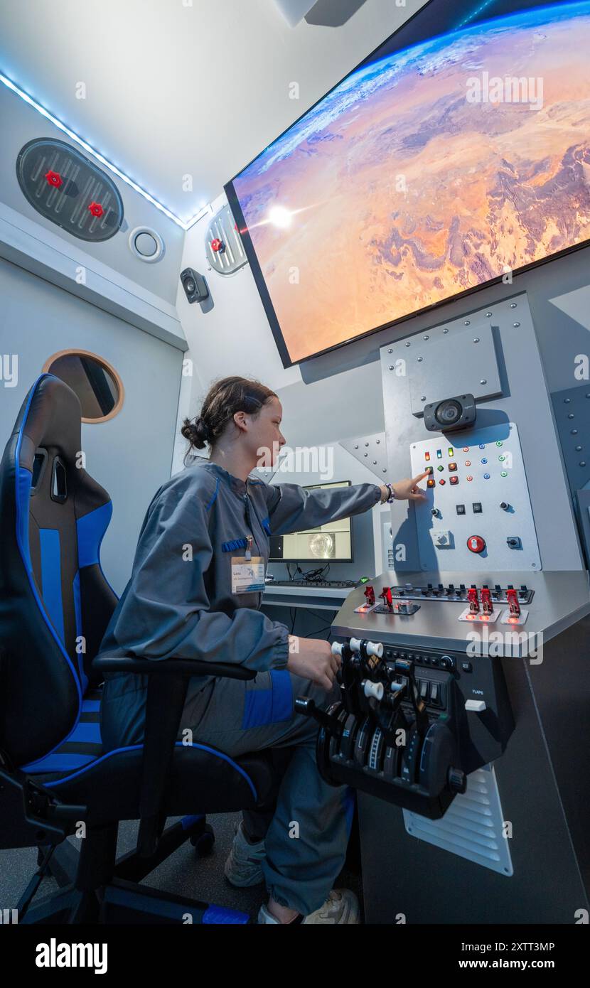 FILED - 15 août 2024, Saxe, Chemnitz : dans le cockpit de la nouvelle capsule spatiale du Centre cosmonaute Sigmund Jähn à Chemnitz, Lena Werner guide à travers l'immensité de l'espace. Après une rénovation complète, la capsule spatiale sera lancée à nouveau pour le 60e anniversaire de l'installation avec des vols spatiaux simulés pour les passagers de tous âges. Samedi (17.08.2024), le Solaris Development Center, sponsor du Cosmonaut Center, organise une célébration d’anniversaire. L'installation pour enfants et jeunes est dédiée aux voyages spatiaux depuis 1964 et apporte l'immensité bey Banque D'Images