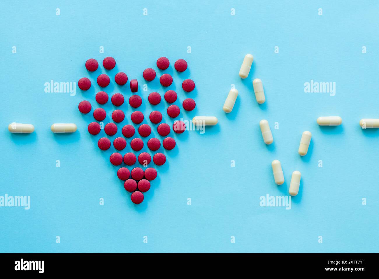 pilules rouges vives en forme de cœur sur un fond bleu clair.abstract sur le thème d'un cœur sain, les maladies cardiaques Banque D'Images