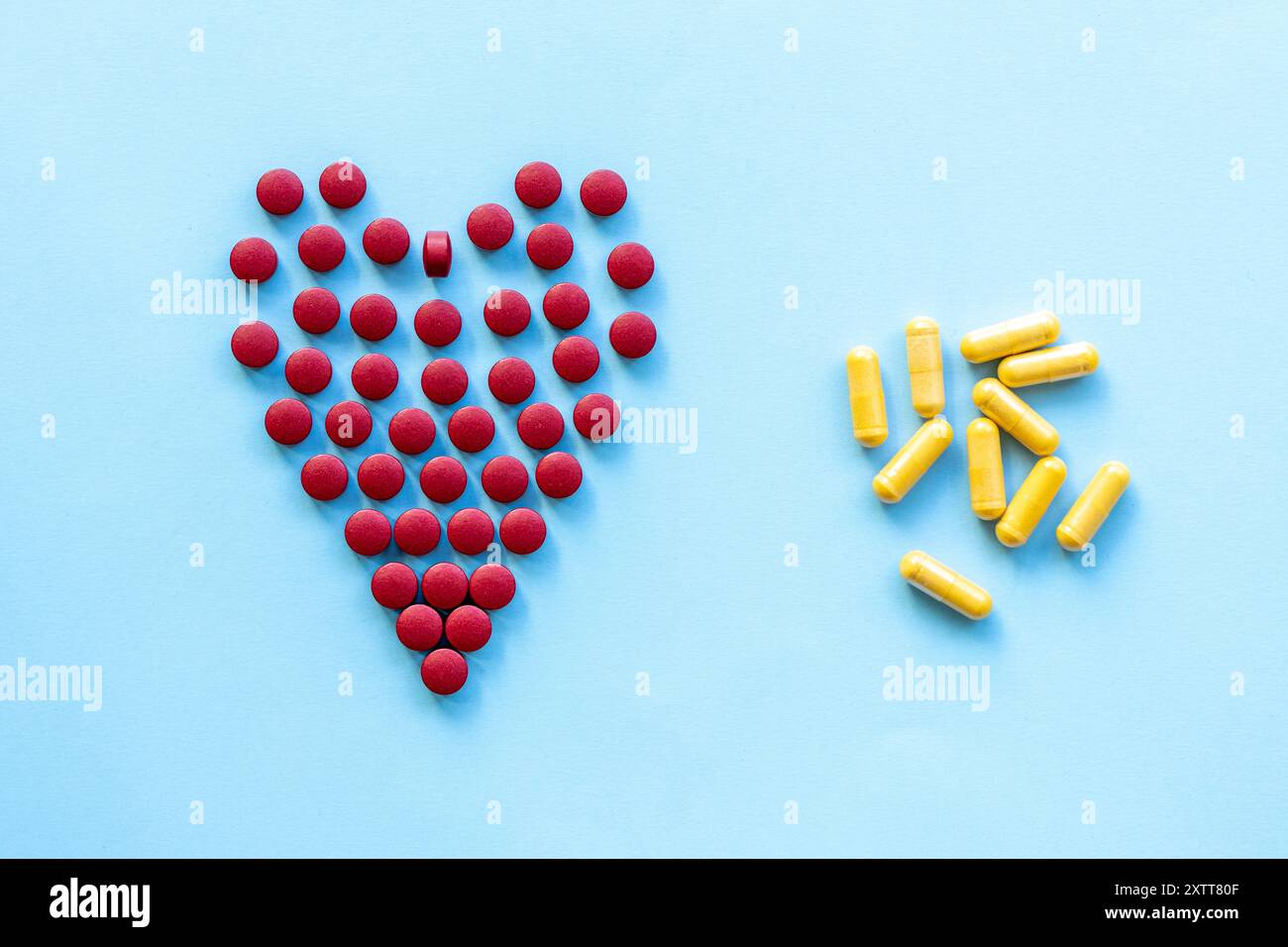 pilules rouges vives en forme de cœur sur un fond bleu clair.abstract sur le thème d'un cœur sain, les maladies cardiaques Banque D'Images