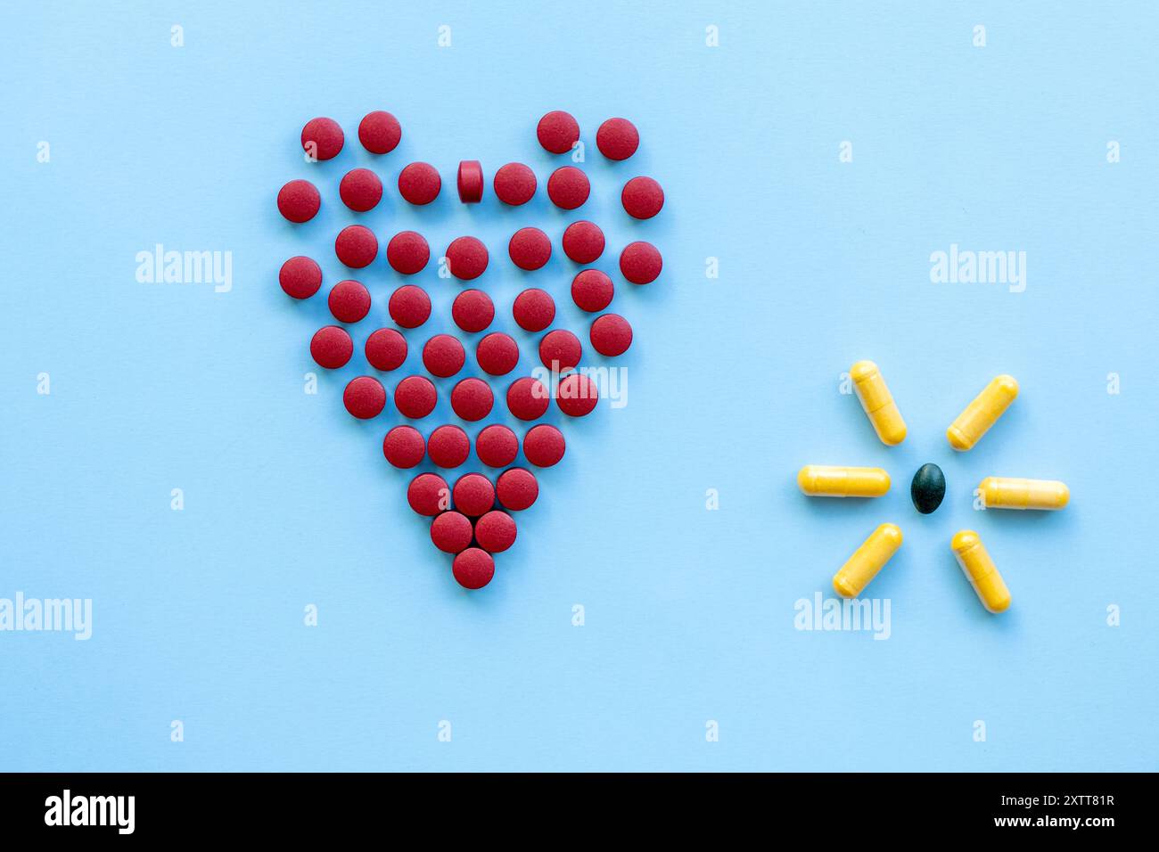 pilules rouges vives en forme de cœur sur un fond bleu clair.abstract sur le thème d'un cœur sain, les maladies cardiaques Banque D'Images