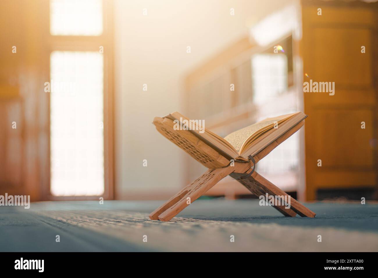 Le Saint Coran : le livre sacré des musulmans, magnifiquement exposé dans une mosquée ornée de calligraphie arabe. Il reflète le profond signifiant spirituel Banque D'Images