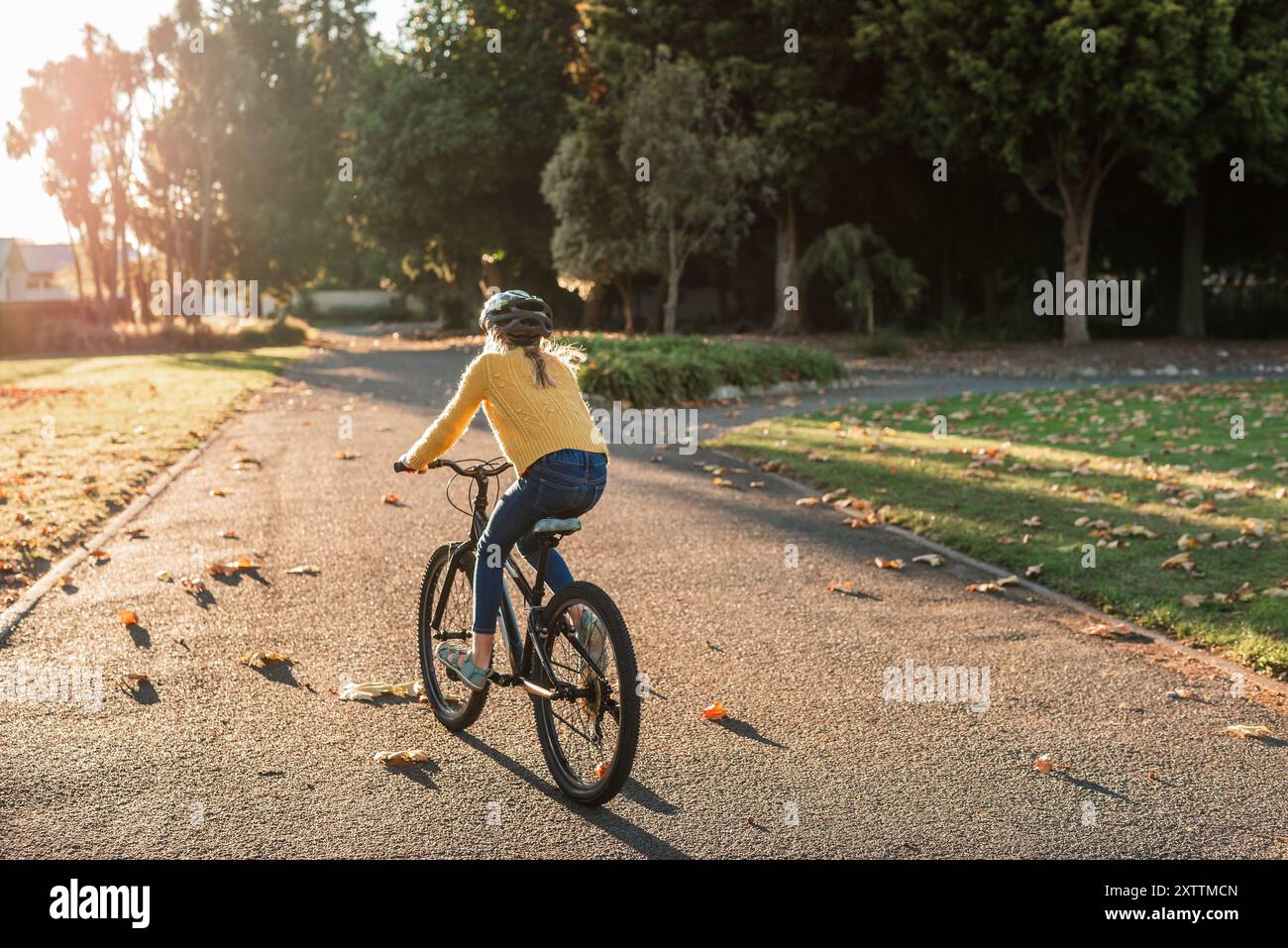 Fille vélo d'équitation dans la belle lumière le jour d'automne Banque D'Images