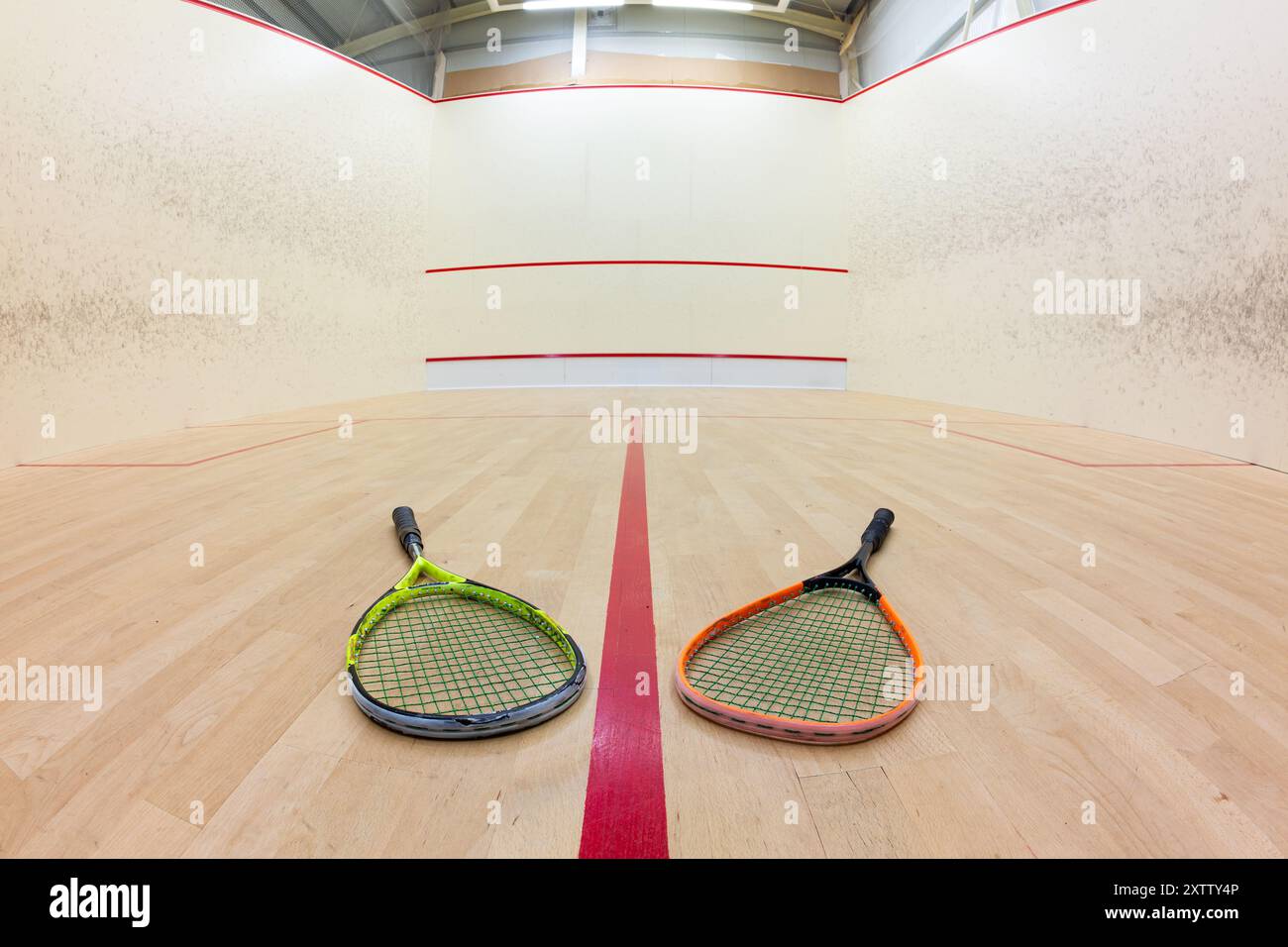Court de squash vide et raquettes sur le plancher en bois. Vue large et basse, pas de personnes. Banque D'Images