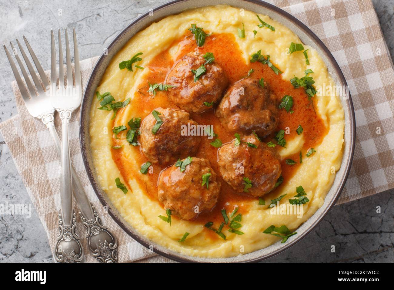 Boulettes de viande frites avec sauce épicée et polenta de maïs gros plan dans un bol sur la table. Vue horizontale de dessus Banque D'Images