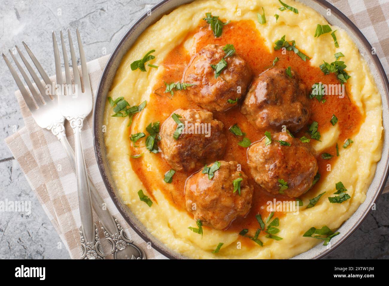 Boulettes de viande italiennes classiques avec polenta crémeuse en gros plan sur le bol sur la table. Vue horizontale de dessus Banque D'Images