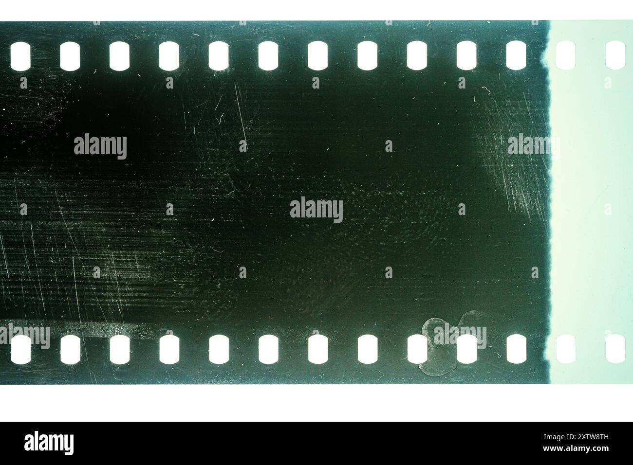 Texture ou surface poussiéreuse et rugueuse du film 35 mm.Film perforé rayé isolé sur fond blanc. Banque D'Images