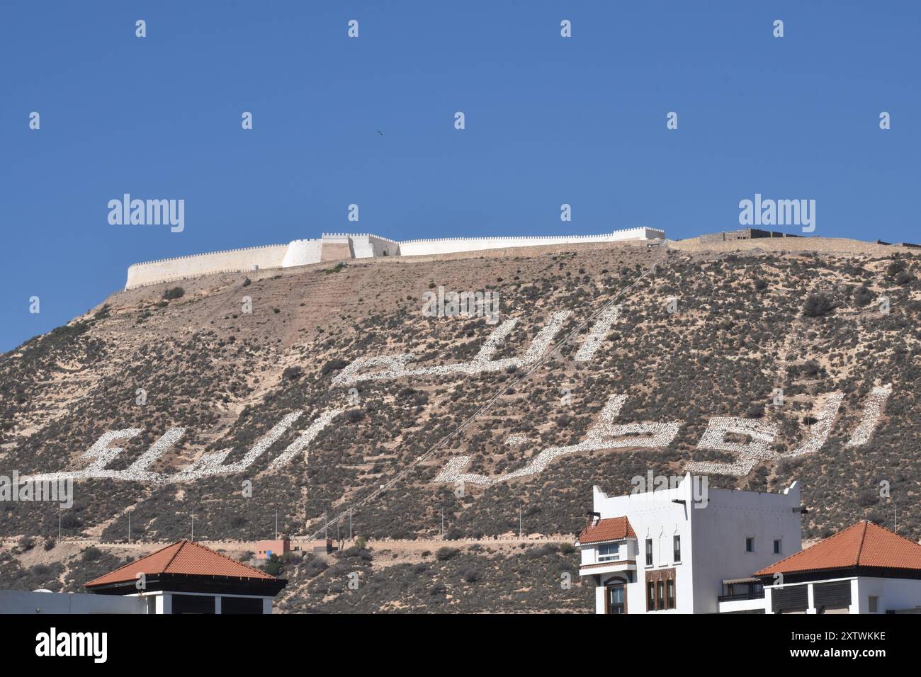Une vue depuis la marina d'Agadir, Maroc au fort à flanc de montagne. Avec inscription arabe sur le flanc de la colline. Banque D'Images