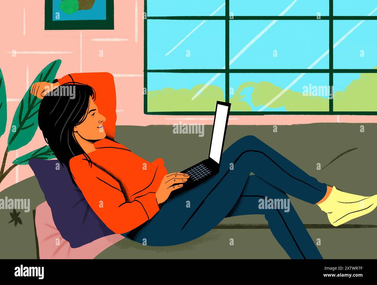 Femme en pull orange se relaxant avec son ordinateur portable dans un environnement domestique confortable par une grande fenêtre. Banque D'Images