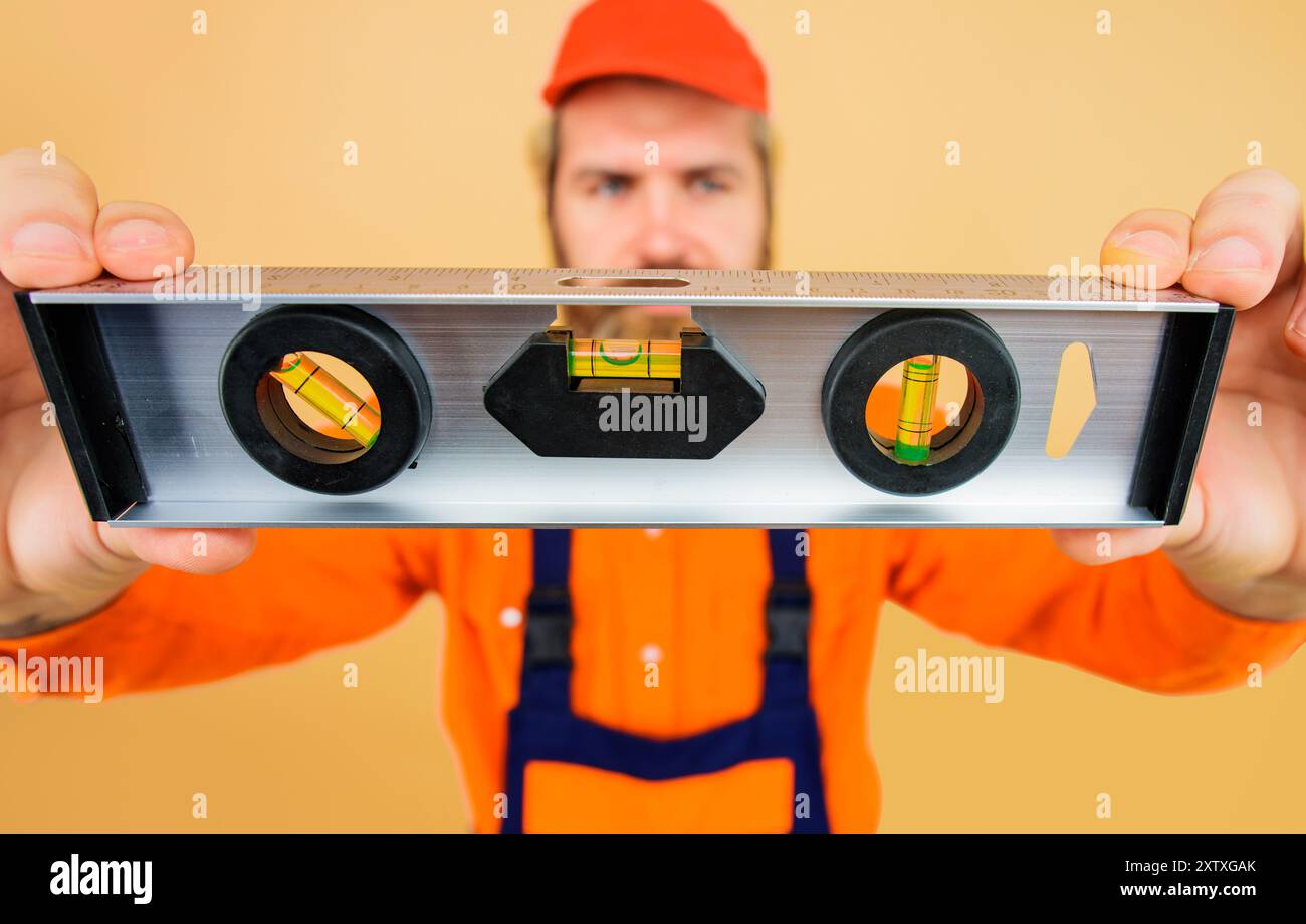 Bel architecte ou ouvrier de construction avec niveau de construction. Niveau de bâtiment professionnel. Niveau antichoc. Concept de construction, rénovation. Banque D'Images