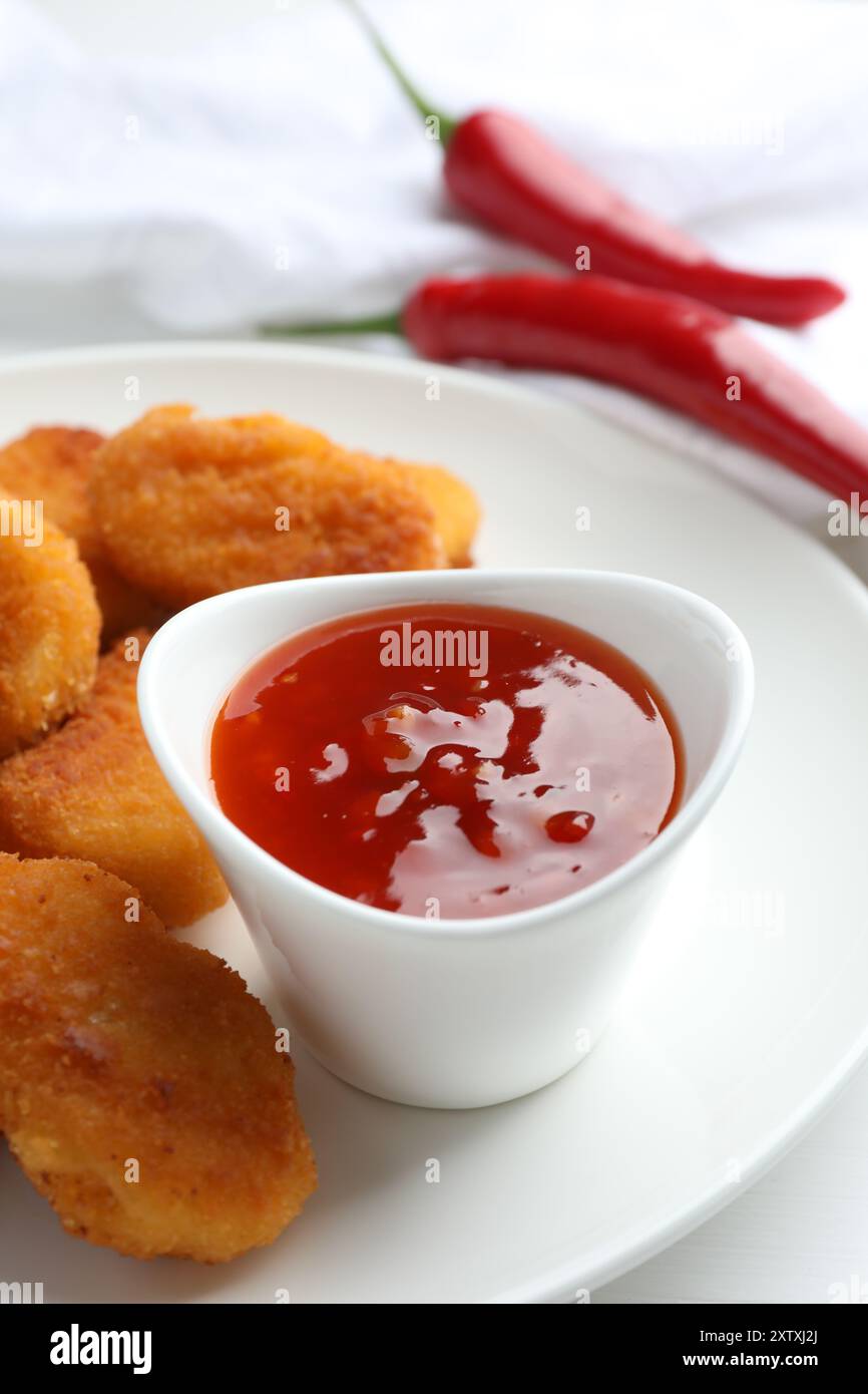 Sauce Chili et nuggets de poulet sur table blanche Banque D'Images