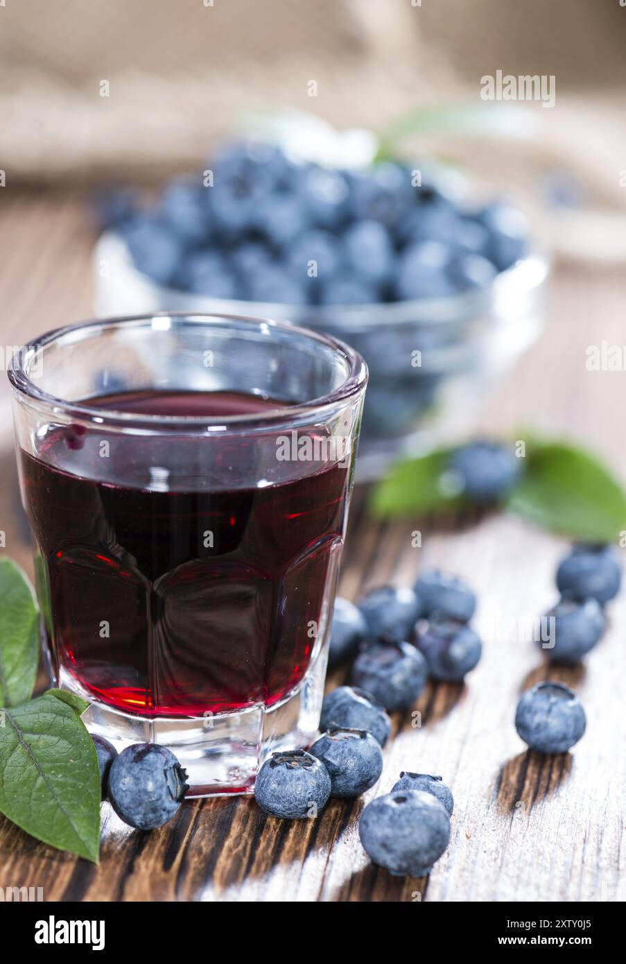 Liqueur de bleuets dans un verre (sur fond de bois) Banque D'Images