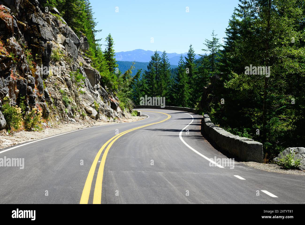 Pittoresque Stevens Canyon Road traversant le parc national de Mount Rainier avec un côté accidenté et un mur de pierre Banque D'Images