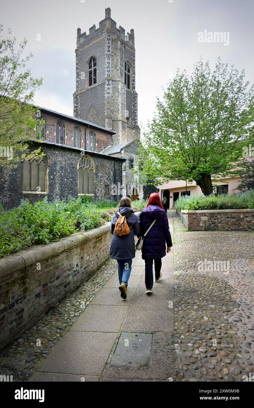deux femmes marchant ensemble vers l'église st george, tombland, norwich, norfolk Banque D'Images