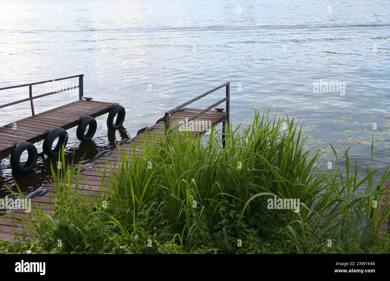 Gros plan de ponts en bois d'époque sur les rives d'une rivière ou d'un lac, une soirée tranquille en pleine nature, un quai Banque D'Images