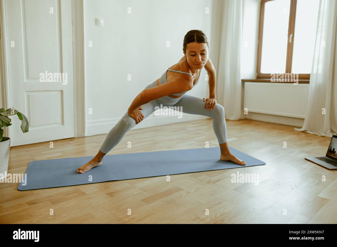 Pose de yoga dynamique dans un espace intérieur lumineux et accueillant pour une expérience de pratique optimale Banque D'Images