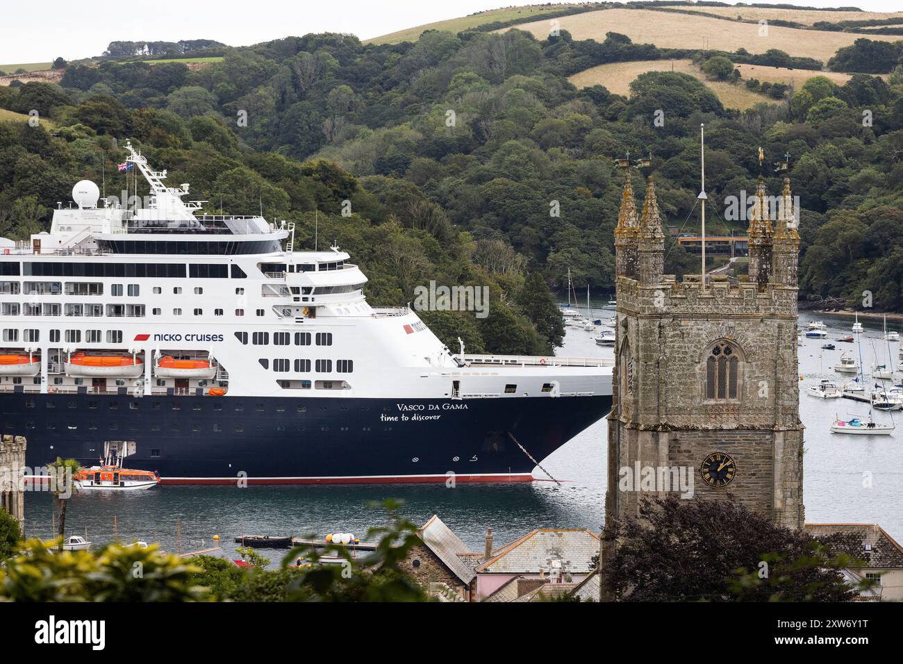 Fowey, Royaume-Uni. 17 août Le navire de croisière Vasco de Gama domine la petite ville côtière de Fowey, Cornouailles, Royaume-Uni. Le bateau de croisière de 58 000 tonnes est exploité par la ligne de croisière allemande Nick Cruises contient 1000 passagers, ce qui fait que la petite communauté de 2 315 personnes a presque doublé de taille ! L'année dernière, il y a eu un tollé de la population locale quand le Spirit of Adventure, est venu en ville et a gâché la vue de la ville pittoresque. Crédit : Mark Passmore / Alamy Live News Banque D'Images