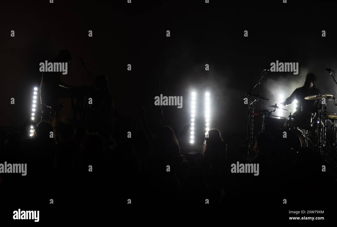 Concert de musique rock avec un éclairage de scène vibrant et une grande foule de fans de musique enthousiastes. Banque D'Images