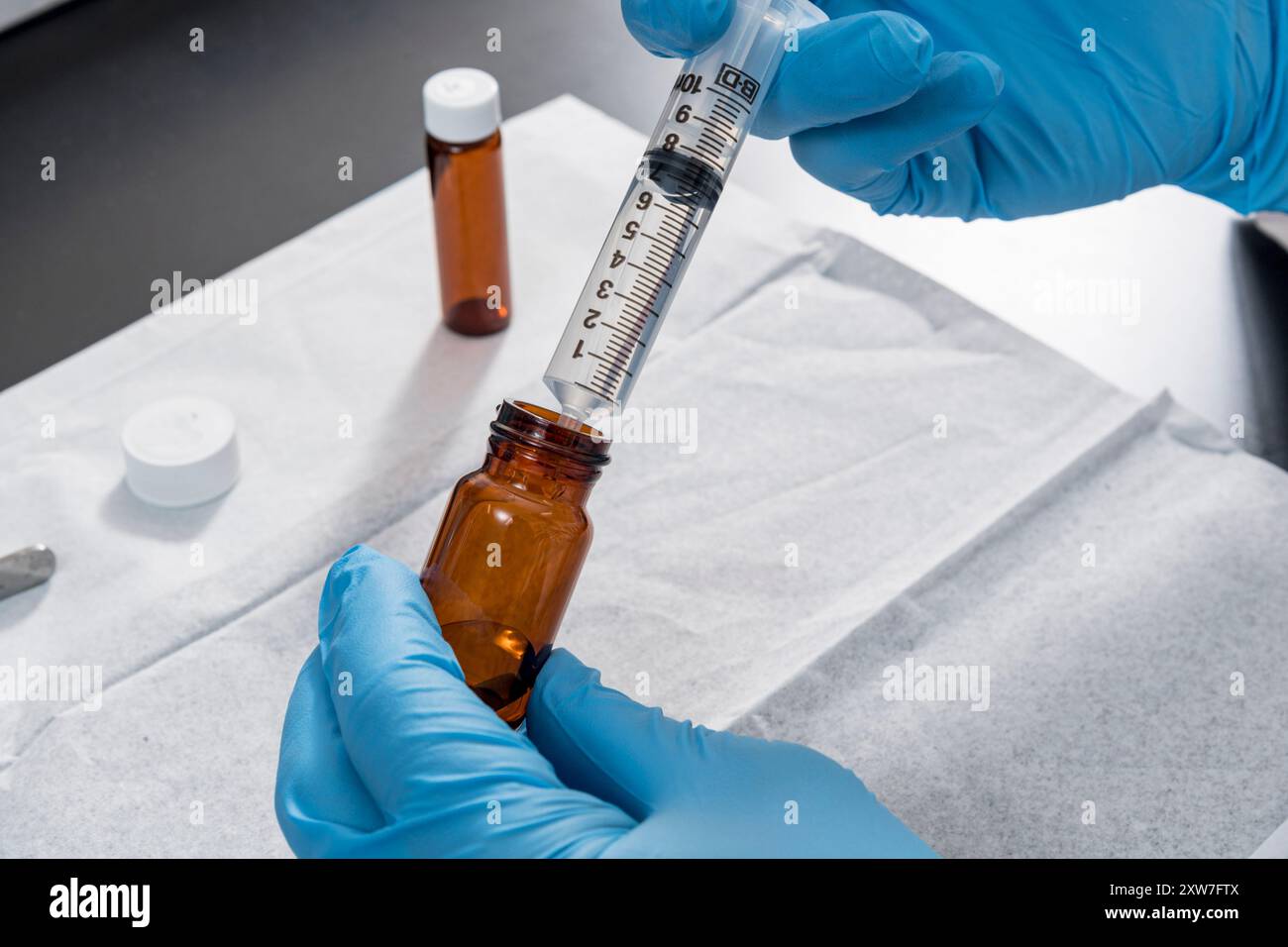 Travailleur de laboratoire tirant le liquide hors du flacon en laboratoire, New Jersey, États-Unis Banque D'Images Travailleur de laboratoire tirant le liquide hors du flacon en laboratoire, New Jersey, États-Unis Banque D'Images