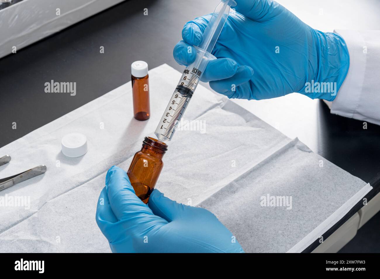 Travailleur de laboratoire tirant le liquide hors du flacon en laboratoire, New Jersey, États-Unis Banque D'Images Travailleur de laboratoire tirant le liquide hors du flacon en laboratoire, New Jersey, États-Unis Banque D'Images