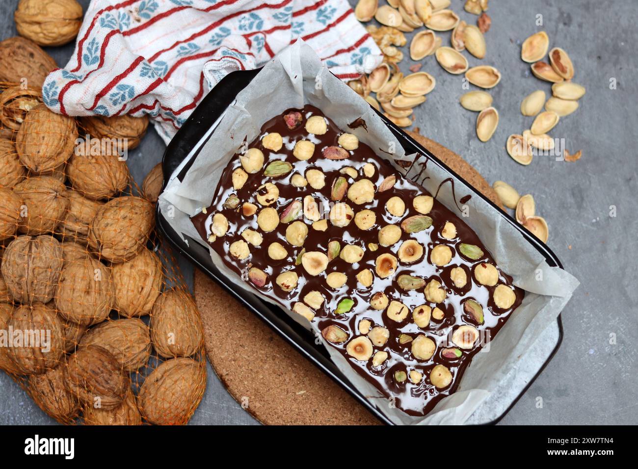 Gâteau au chocolat avec pistaches et noix dans une plaque à pâtisserie Banque D'Images