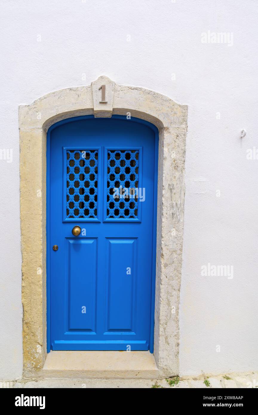 Porte d'entrée bleu vif à Lisbonne, Portugal détaillant des ferronneries complexes. Banque D'Images