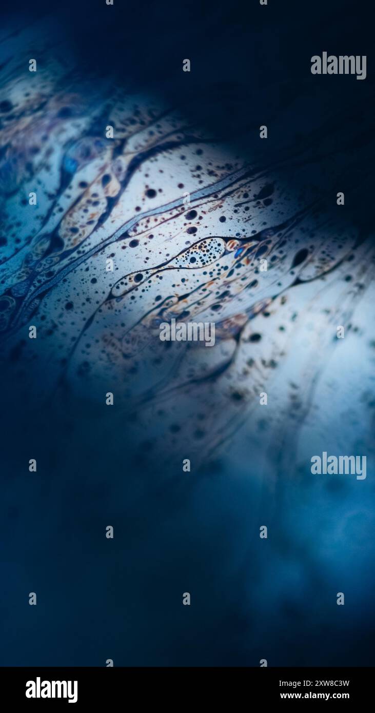 Texture fluide pétillante. Liquide acide. Flou défocalisé d'émulsion d'huile de couleur bleu orange fuite flaque slick sur fond d'art abstrait d'évasement de lumière noire sombre. Banque D'Images