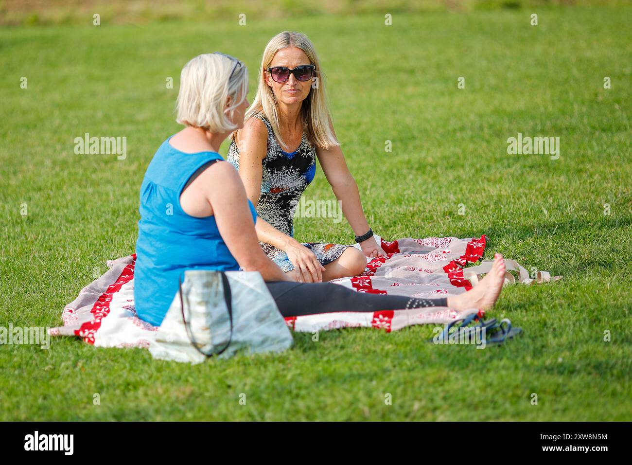 Les Burys, Godalming. 18 août 2024. Un après-midi chaud et ensoleillé pour les Home Counties. Les gens apprécient la musique dans le parc au Godalming Bandstand dans le Surrey. Tous les dimanches après-midi pendant les mois d'été, de la musique live est jouée avec une variété de genres couverts. Cet après-midi, c'était le tour de 'The Band of the Surrey Yeomanry', parrainé par BL Vision de Farncombe. Crédit : james jagger/Alamy Live News Banque D'Images