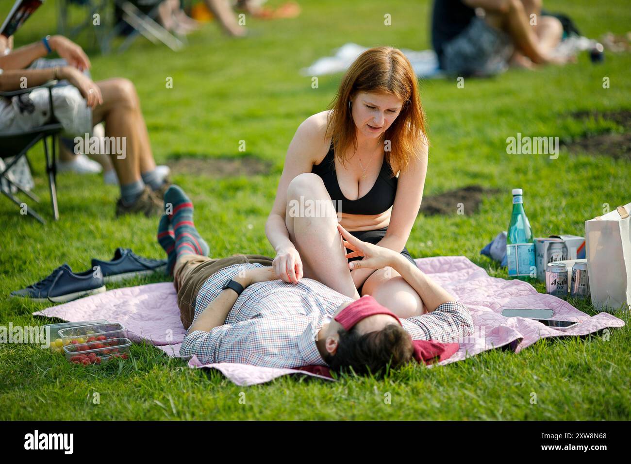 Les Burys, Godalming. 18 août 2024. Un après-midi chaud et ensoleillé pour les Home Counties. Les gens apprécient la musique dans le parc au Godalming Bandstand dans le Surrey. Tous les dimanches après-midi pendant les mois d'été, de la musique live est jouée avec une variété de genres couverts. Cet après-midi, c'était le tour de 'The Band of the Surrey Yeomanry', parrainé par BL Vision de Farncombe. Crédit : james jagger/Alamy Live News Banque D'Images