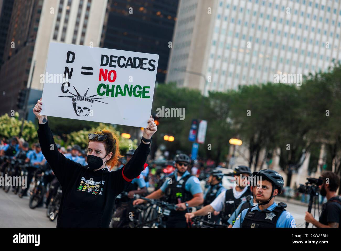 Chicago, États-Unis. 18 août 2024. CHICAGO, ILLINOIS - 18 AOÛT : une femme tient une pancarte lisant « DNC = Decades No change », alors que des manifestants pro-palestiniens défilent avant la Convention nationale démocrate le 18 août 2024 à Chicago, Illinois. La convention se déroule du 19 au 22 août. Crédit : Jeremy Hogan/Alamy Live News Banque D'Images