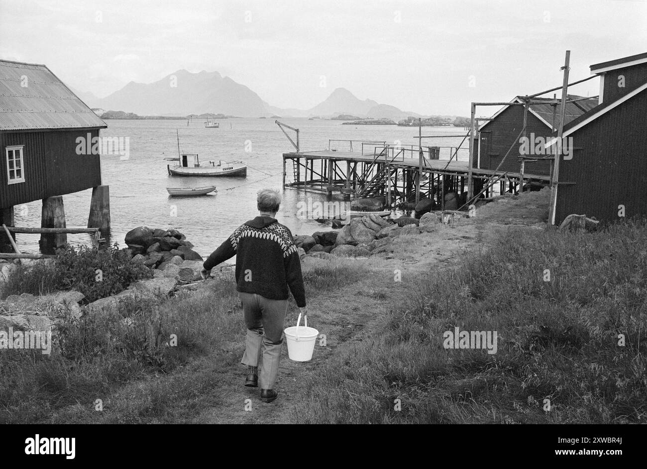 Current 29-1-1971 : personnages célèbres dans le rorbua. Le premier ministre, sa femme et son fils se sont installés dans un rorbu à Kræmmervika à Ballstad dans les Lofoten pour passer quelques semaines de vacances indispensables dans un environnement relaxant. après la pression de travail difficile du ressort. Mauvaise chance à la pêche aujourd'hui! Mais le marchand avait une belle plie, que le premier ministre lui-même s'occupe d'abord, avant de devoir aller chercher de l'eau au robinet d'eau commun, tandis que Mme Randi s'occupe de la plie. Photo : Sverre A. Børretzen/Aktuell/NTB ***PHOTO NON TRAITÉE*** le texte de cette image est traduit automatiquement Banque D'Images