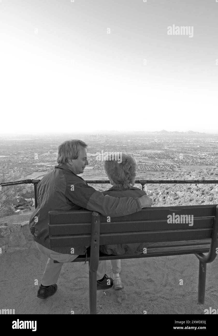 Couple caucasien dans les années 50 profitant de la vue depuis un banc à Dobbins Lookout, South Mountain Park, Phoenix, Arizona, États-Unis. Banque D'Images
