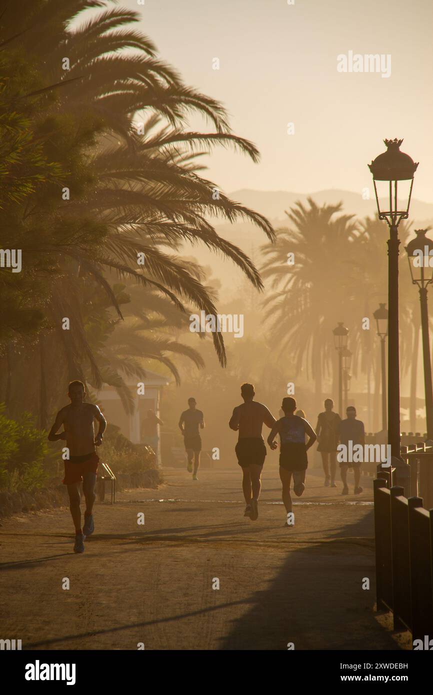 Joggers matinaux le long de la plage Marbella, Andalousie, Espagne. Banque D'Images