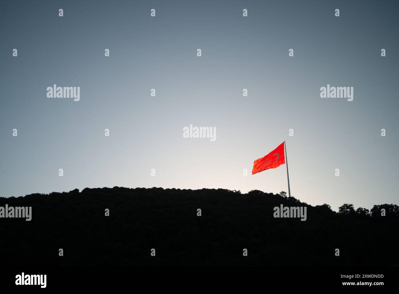 Une image puissante du drapeau turc agitant fièrement au sommet d'une montagne, symbolisant la force, la liberté et la fierté nationale, sur fond de vaste Banque D'Images Une image puissante du drapeau turc agitant fièrement au sommet d'une montagne, symbolisant la force, la liberté et la fierté nationale, sur fond de vaste Banque D'Images