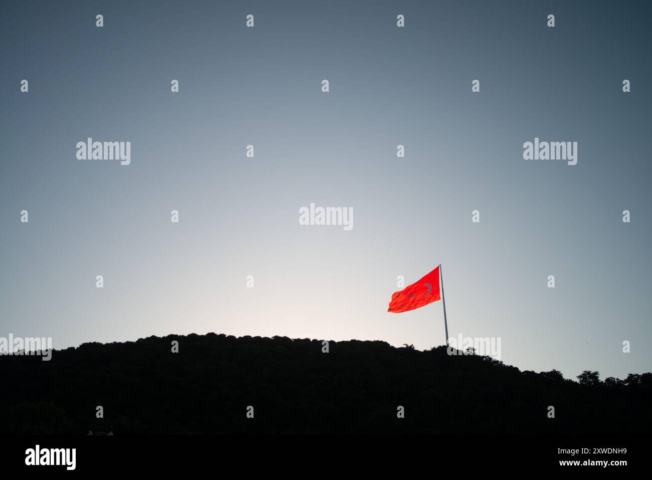Une image puissante du drapeau turc agitant fièrement au sommet d'une montagne, symbolisant la force, la liberté et la fierté nationale, sur fond de vaste Banque D'Images Une image puissante du drapeau turc agitant fièrement au sommet d'une montagne, symbolisant la force, la liberté et la fierté nationale, sur fond de vaste Banque D'Images