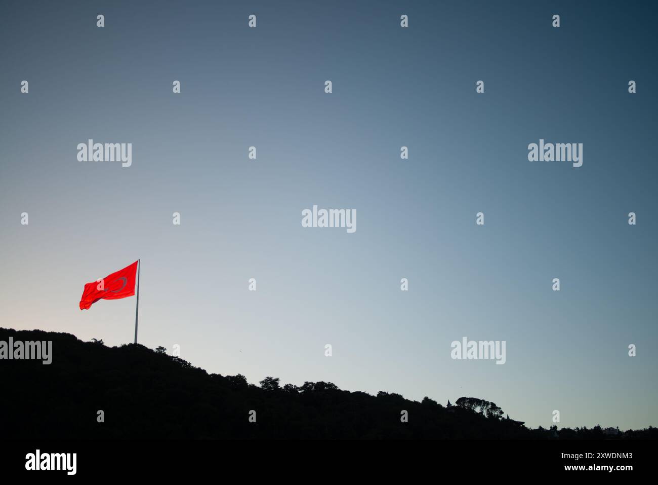 Une image puissante du drapeau turc agitant fièrement au sommet d'une montagne, symbolisant la force, la liberté et la fierté nationale, sur fond de vaste Banque D'Images Une image puissante du drapeau turc agitant fièrement au sommet d'une montagne, symbolisant la force, la liberté et la fierté nationale, sur fond de vaste Banque D'Images