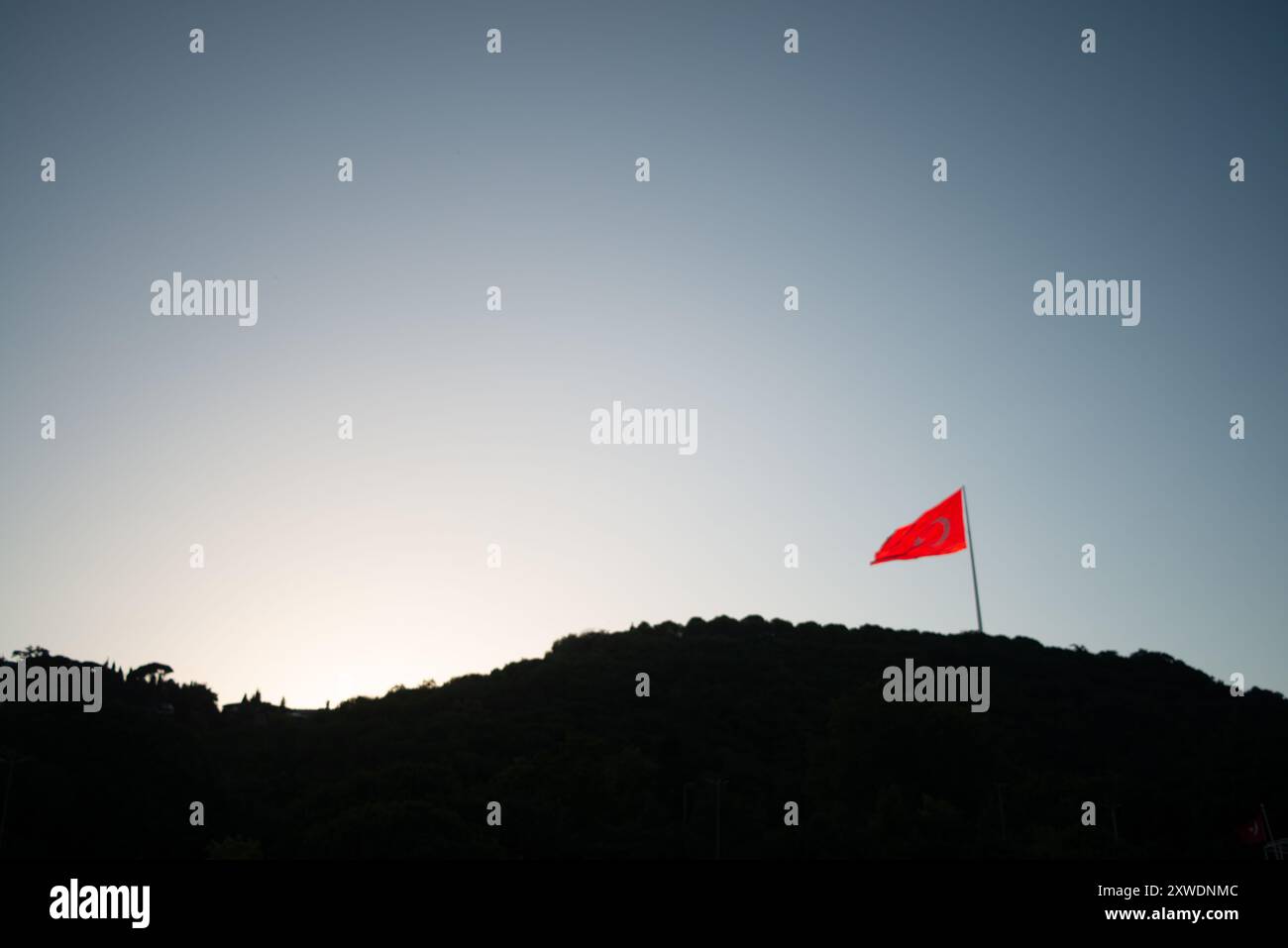 Une image puissante du drapeau turc agitant fièrement au sommet d'une montagne, symbolisant la force, la liberté et la fierté nationale, sur fond de vaste Banque D'Images