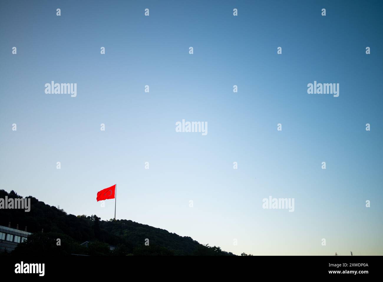 Une image puissante du drapeau turc agitant fièrement au sommet d'une montagne, symbolisant la force, la liberté et la fierté nationale, sur fond de vaste Banque D'Images Une image puissante du drapeau turc agitant fièrement au sommet d'une montagne, symbolisant la force, la liberté et la fierté nationale, sur fond de vaste Banque D'Images