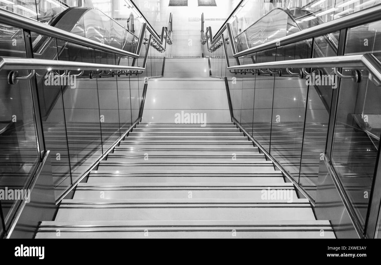 Escalier public à la gare ou au centre commercial pour sortie, entrée, urgence. Escalier à l'intérieur du métro, métro avec main courante proprement en acier. Plate-forme moderne avec gr Banque D'Images