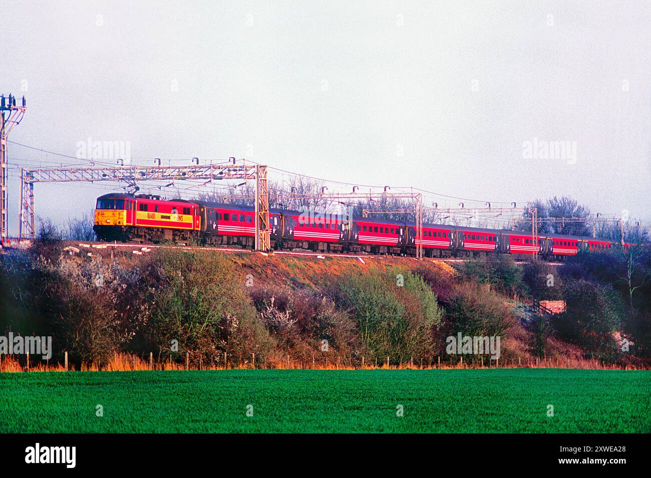 Une locomotive électrique de classe 86 numéro 86401 dans la livrée EWS travaillant un service Virgin West Coast à Ashton le 29 mars 2002. Banque D'Images