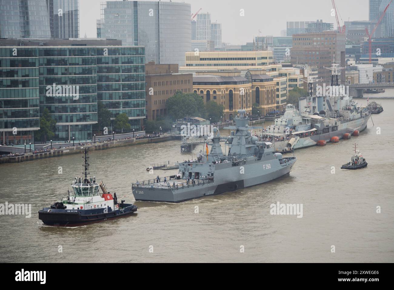 LONDRES - ROYAUME-UNI - 19 AOÛT : un Braunschweig (F260), le navire de tête de la corvette de classe Braunschweig de la marine allemande, est remorqué vers l'arrière à travers Tower Bridge en descendant la Tamise, le 19 août 2024 à Londres Royaume-Uni. Banque D'Images