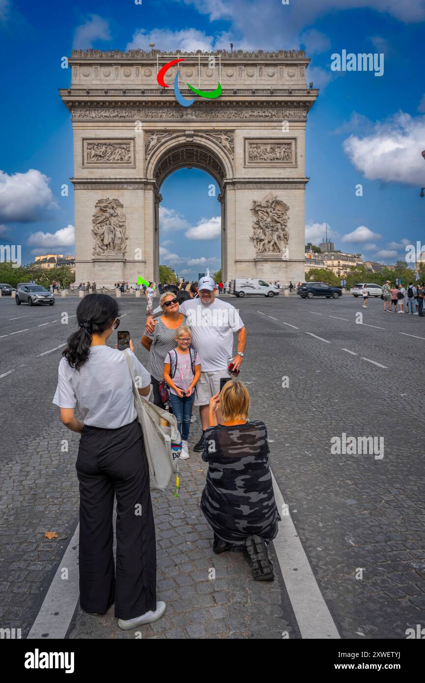 Paris, France - 08 19 2024 : Jeux Olympiques Paris 2024. Vue de l'Arc de Triomphe avec le symbole des jeux paralympiques et des touristes en face Banque D'Images