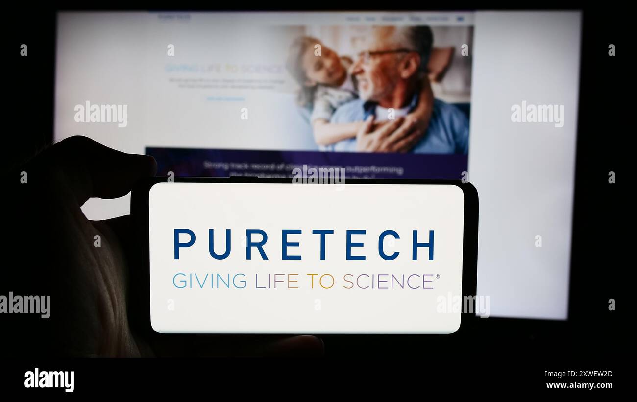 Personne tenant un smartphone avec le logo de la société de biotechnologie PureTech Health plc en face du site Web. Concentrez-vous sur l'affichage du téléphone. Banque D'Images