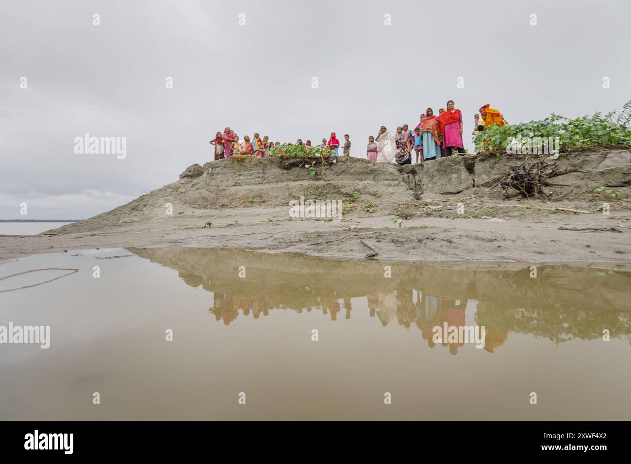 Femmes et enfants de l'omble de Nayer sur la rive de la rivière Brahmapoutre. Pendant et après la dernière inondation, la rivière a divisé l'omble presque en deux et emporté d'énormes superficies de terre. Banque D'Images
