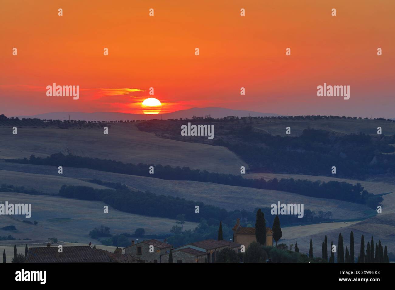 Asciano, Italie - 22 juillet 2023 : Paysage toscan au coucher du soleil. L'un des endroits les plus célèbres avec des cyprès et une route de gravier blanc en Toscane, nea Banque D'Images