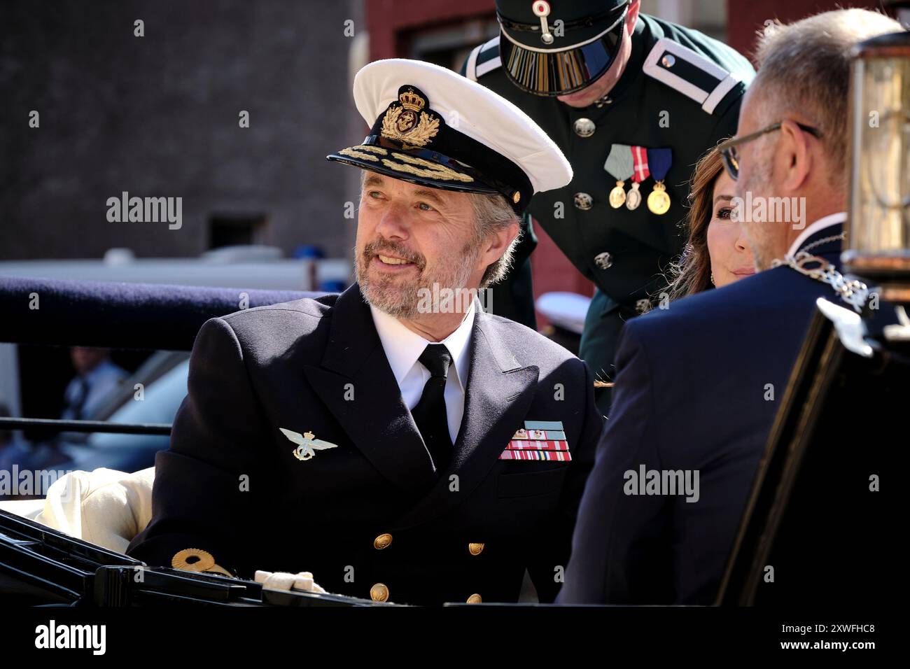 Bornholm, Danemark. 19 août 2024. Le roi Frederik X et la reine Mary visitent la municipalité régionale de Bornholm, le lundi 19 août 2024. Le couple royal arrive avec le navire royal Dannebrog au Honnoerkajen dans le port de Roenne. Ici leurs Majestés sont reçus par, entre autres, le maire Jacob Troest. Un clin d'œil est levé, et le corps musical des Royal Life Guards joue « King Christian ». (Photo : Pelle Rink/Scanpix 2024) crédit : Ritzau/Alamy Live News Banque D'Images