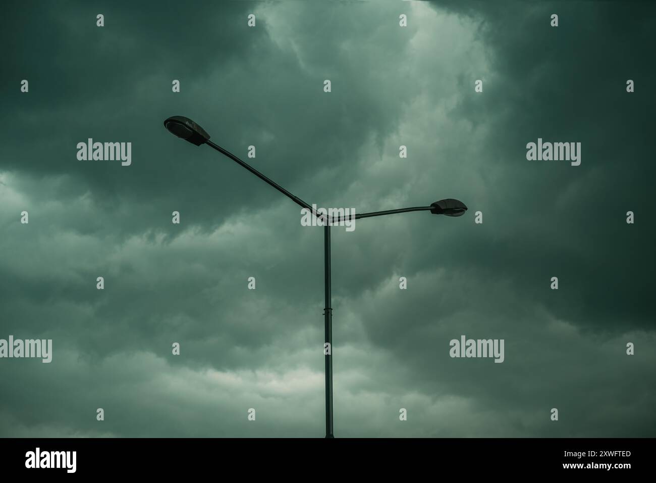 Silhouette de lampadaire de rue contre les nuages orageux sombres en été, mise au point sélective Banque D'Images