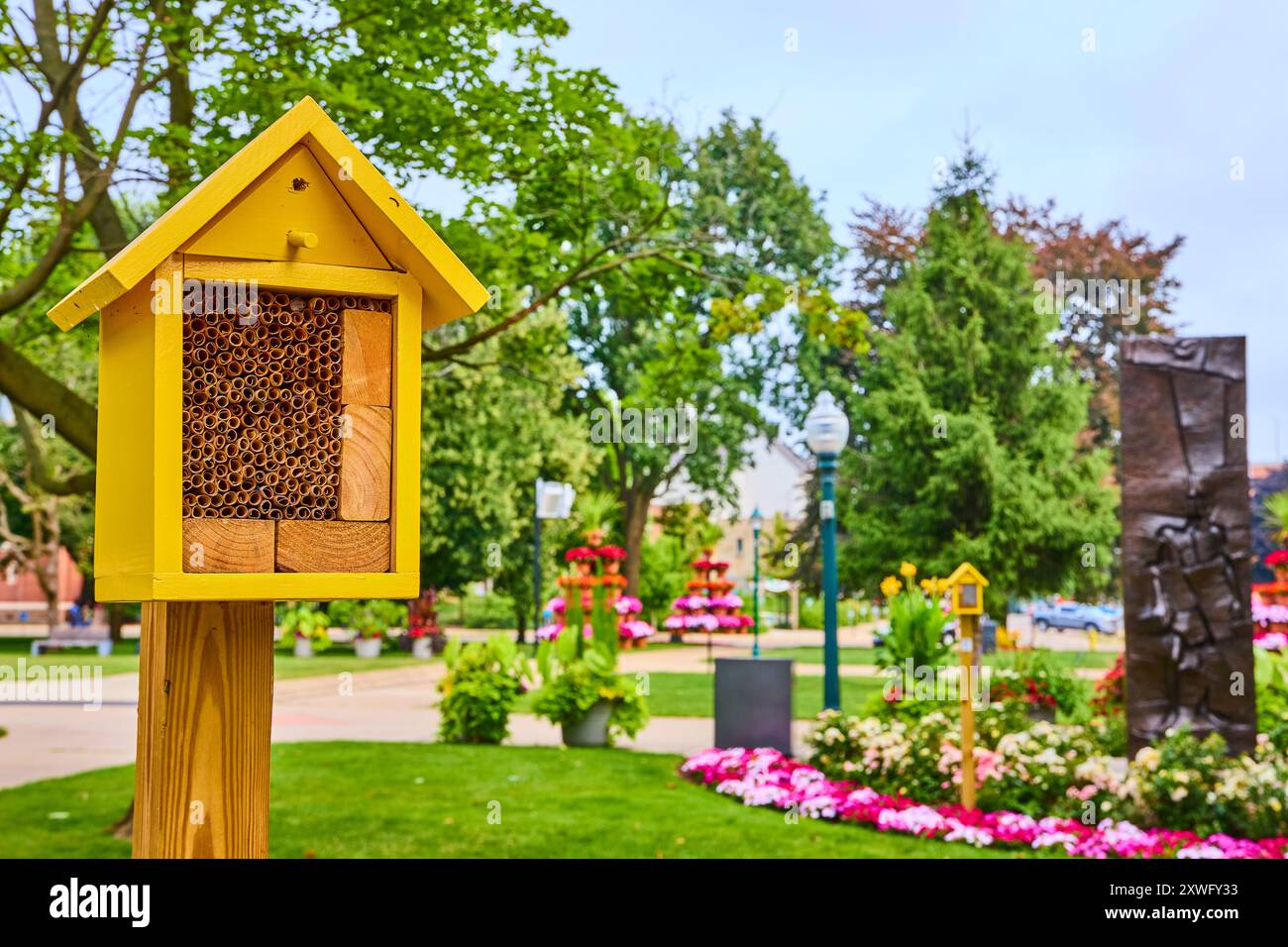 Yellow Insect House dans un parc urbain luxuriant avec de l'art et des fleurs, vue au niveau des yeux Banque D'Images