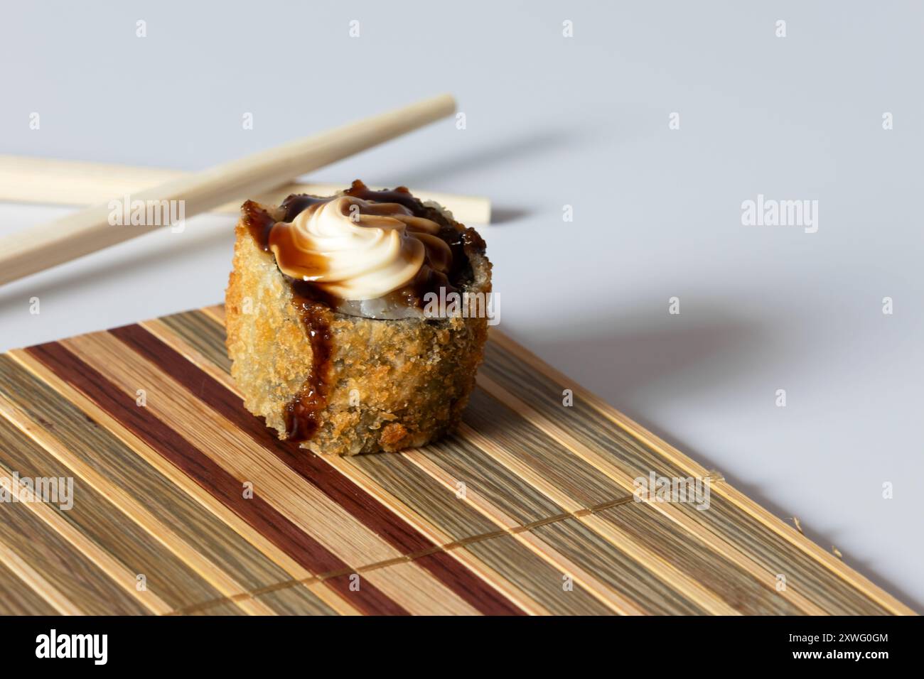 Un rouleau chaud garni de fromage à la crème et de sauce tare sur un petit tapis. Banque D'Images