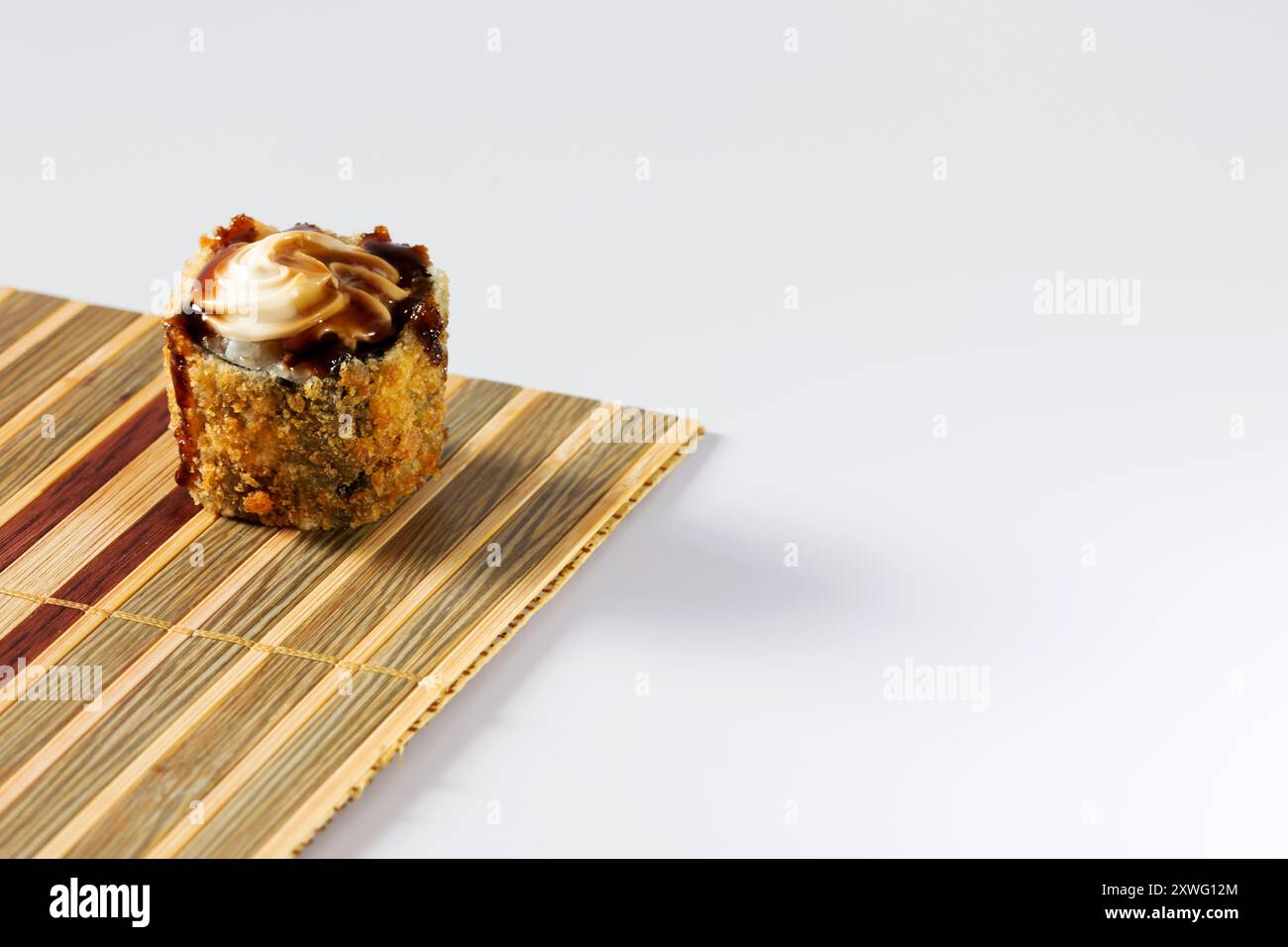 rouleau chaud garni de fromage à la crème et de sauce tare sur un petit tapis de bambou. Banque D'Images