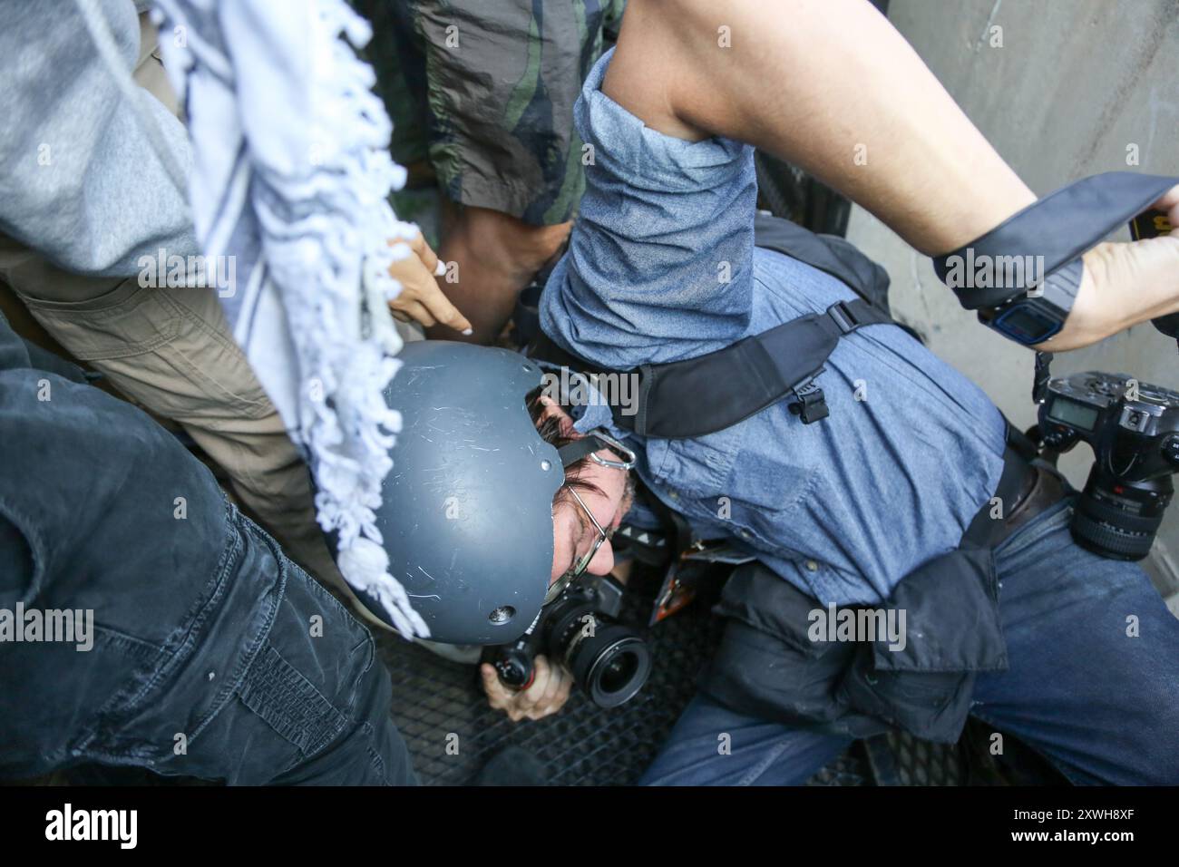 Chicago, États-Unis. 19 août 2024. Un photographe est poussé dans une bagarre avec la police après que des manifestants de la première marche nationale sur le DNC ont brisé la barrière entourant le périmètre du United Center depuis le Park 578, Chicago, il le 19 août 2024. C'était le premier jour de la Convention démocratique et les manifestants voulaient envoyer un message au DNC. (Photo par : Alexandra Buxbaum/Sipa USA) crédit : Sipa USA/Alamy Live News Banque D'Images